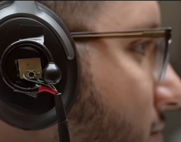 Man in glasses wearing black headphone with wires sticking out